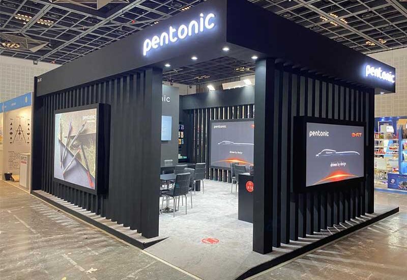 An exhibition booth with modern design and interactive screens at a trade show in 2025.