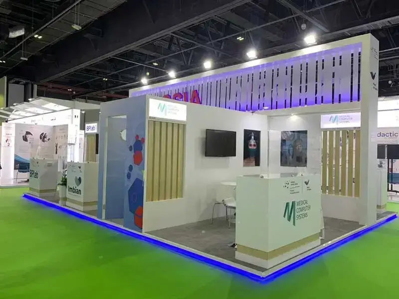 An exhibition booth at an international trade show with illuminated signage and branded displays