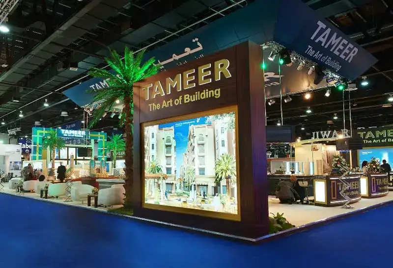 Exhibition stand showcasing real estate projects with branding and lighting at a trade show in Dubai.
