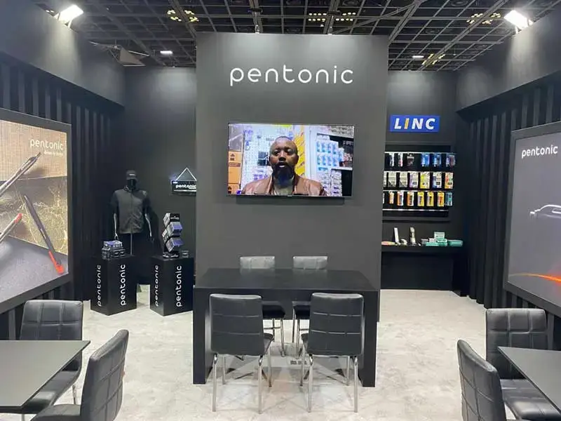 Exhibition stand with product displays and video presentations at a trade show.