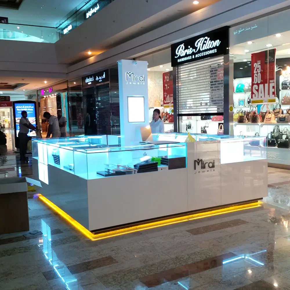 Promotional stand for showcasing jewelry at a shopping mall with bright lighting and clear glass displays.